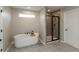 Modern bathroom featuring a freestanding tub, a walk-in shower with a glass door, and stylish flooring at 8160 Shaldon Ct, Zionsville, IN 46077