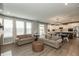 Open living room connecting to the kitchen, featuring hardwood floors and neutral-colored sofas at 8160 Shaldon Ct, Zionsville, IN 46077