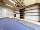 Garage with plentiful shelving, blue matting, and an outside view at 8616 Old Dominion Ct, Indianapolis, IN 46231