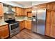 Modern kitchen with stainless steel appliances, light wood cabinetry, and a stylish range hood at 8616 Old Dominion Ct, Indianapolis, IN 46231