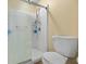 Clean bathroom with a white shower, a white toilet, and a beige painted wall at 919 Oak Park Dr, Shelbyville, IN 46176