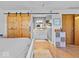 A bedroom featuring hard wood floors, a sliding barn door leading to the bathroom, and neutral decor at 919 Oak Park Dr, Shelbyville, IN 46176