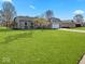 Lush green lawn surrounds this single-story home with a two-car garage and brick facade at 919 Oak Park Dr, Shelbyville, IN 46176