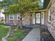Close-up of a brick home's entry, with a landscaped garden, walkway and colorful welcome decor at 919 Oak Park Dr, Shelbyville, IN 46176
