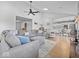 Spacious living room featuring a comfortable sectional sofa, ceiling fan, and an open layout flowing into the kitchen at 919 Oak Park Dr, Shelbyville, IN 46176
