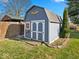 Well-kept backyard shed with blue siding, a gabled roof, and a small garden area, providing convenient storage at 919 Oak Park Dr, Shelbyville, IN 46176