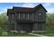 Charming two-story home with a covered porch, brick accents and lush landscaping at 9222 Anthem Ave, Plainfield, IN 46168