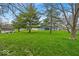 Spacious backyard featuring mature trees, a shed and lush green grass at 9328 Haddington W Dr, Indianapolis, IN 46256