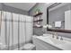 Bathroom with gray walls, floating shelves, white cabinets, and shower with a striped curtain at 9328 Haddington W Dr, Indianapolis, IN 46256
