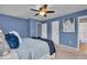 Relaxing bedroom features blue walls, plush bedding, and a ceiling fan for added comfort at 9328 Haddington W Dr, Indianapolis, IN 46256