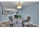 Dining area with a round glass table, four chairs, modern light fixture and open access to living room at 9328 Haddington W Dr, Indianapolis, IN 46256