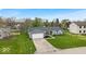 Well-maintained single-story home with lush green lawn, two-car garage, and a quaint front porch at 9328 Haddington W Dr, Indianapolis, IN 46256