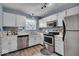 Functional kitchen featuring white cabinets, stainless steel appliances, and modern countertops at 9328 Haddington W Dr, Indianapolis, IN 46256