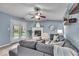 Cozy living room with a grey sectional, fireplace, and doors that lead to the backyard at 9328 Haddington W Dr, Indianapolis, IN 46256
