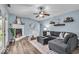 Bright living room featuring a comfortable grey sectional sofa, fireplace, and wood flooring at 9328 Haddington W Dr, Indianapolis, IN 46256