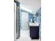 Bathroom features skylight, blue scenic wallpaper, white tile floor, and sink with navy blue cabinet at 9435 Tamarack Dr # 94, Indianapolis, IN 46260
