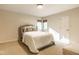 Neutral bedroom with a upholstered bed and headboard, carpet flooring, and two windows for lots of natural light at 9435 Tamarack Dr # 94, Indianapolis, IN 46260