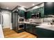 This kitchen features dark green cabinets, stainless steel appliances, white countertops, and a white and green backsplash at 9435 Tamarack Dr # 94, Indianapolis, IN 46260