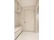 Bright mudroom with storage bench, coat hooks, white tile floors, and a door to the outside at 9435 Tamarack Dr # 94, Indianapolis, IN 46260