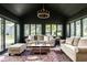 Cozy sunroom filled with natural light, comfortable seating, and an elegant chandelier at 9435 Tamarack Dr # 94, Indianapolis, IN 46260
