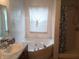 Bathroom features a corner whirlpool tub, window, and shower with curtain at 10629 Simsbury Ct, Indianapolis, IN 46236