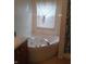 Bathroom features a corner whirlpool tub, window, and tile surround at 10629 Simsbury Ct, Indianapolis, IN 46236
