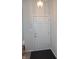 Bright entryway featuring a classic white door with brass hardware, complemented by a modern light fixture at 10629 Simsbury Ct, Indianapolis, IN 46236