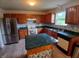 Well-lit kitchen with stainless steel refrigerator, wood cabinets, and an island at 10629 Simsbury Ct, Indianapolis, IN 46236