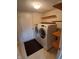 Laundry room featuring a washer, dryer, and shelving for storage, with a glimpse into another room at 10629 Simsbury Ct, Indianapolis, IN 46236