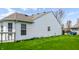 Backyard of home with a white vinyl exterior, green grass and landscaping at 11631 Tucker Ct, Indianapolis, IN 46229