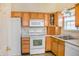 Bright kitchen featuring white appliances, ample wood cabinets, and neutral countertops at 11631 Tucker Ct, Indianapolis, IN 46229