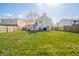 Large, fenced backyard with a spacious lawn, patio furniture, and a serene outdoor setting at 1231 Chesterfield Dr, Anderson, IN 46012