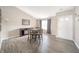 Dining area featuring wood flooring, a square dining table, and natural light from the front door at 1231 Chesterfield Dr, Anderson, IN 46012