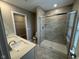 Bright bathroom with double vanity, grey tiled walls, and glass shower at 1268 Newton St, Avon, IN 46123