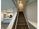 The carpeted staircase connects the first floor to the second, enhancing the open kitchen view at 1268 Newton St, Avon, IN 46123