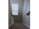 Carpeted staircase leading downwards with wood railing and natural light from a window at 12866 Thames Dr, Fishers, IN 46037