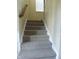 Carpeted staircase with white trim and a wooden handrail leading to the upper level at 12866 Thames Dr, Fishers, IN 46037