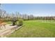 Backyard featuring a well-maintained lawn, garden bed, and a serene pond, creating a peaceful outdoor oasis at 13351 Grosbeak Ct, Carmel, IN 46033