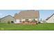 Large backyard with a spacious lawn and outdoor seating area, offering plenty of room for relaxation and recreation at 13351 Grosbeak Ct, Carmel, IN 46033