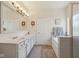 Bright bathroom showcasing double sinks, large mirror, soaking tub and a glass enclosed shower at 13351 Grosbeak Ct, Carmel, IN 46033