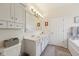 Bright bathroom showcasing double sinks, a large mirror, soaking tub and separate glass enclosed shower at 13351 Grosbeak Ct, Carmel, IN 46033