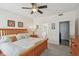Bright bedroom featuring natural wood bed frame, ceiling fan, and ensuite bathroom access at 13351 Grosbeak Ct, Carmel, IN 46033