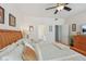 Bright bedroom features natural wood bed frame and ceiling fan with ensuite bathroom access at 13351 Grosbeak Ct, Carmel, IN 46033