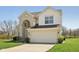 Traditional two-story home with brick facade, attached two-car garage, and manicured lawn on a sunny day at 13351 Grosbeak Ct, Carmel, IN 46033