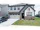 Two-story home featuring gray siding, a two-car garage, and a well-manicured lawn at 15702 Cobbs Crk Ln, Noblesville, IN 46060