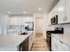 Kitchen featuring white cabinets, modern appliances, a large countertop, and light hardwood flooring at 15702 Cobbs Crk Ln, Noblesville, IN 46060