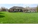 Large backyard with manicured lawn, patio area with a fire pit and seating, perfect for outdoor activities at 16 Corkwood Ct, Brownsburg, IN 46112