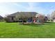 Spacious backyard boasts a brick patio with a fire pit, mature trees, and lush green grass at 16 Corkwood Ct, Brownsburg, IN 46112