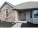 Close-up of a brick home's entryway with a neutral-colored door and a small garden at 16 Corkwood Ct, Brownsburg, IN 46112