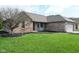 Brick house with green yard, black mulch, large tree, and attached garage at 16 Corkwood Ct, Brownsburg, IN 46112